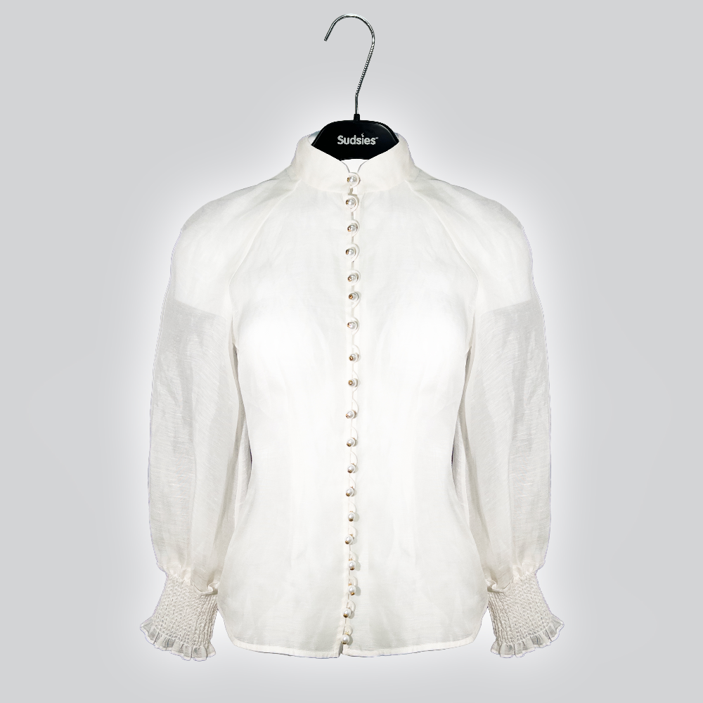 Zimmermann ivory silk blouse with pearl buttons displayed on a Sudsies hanger.